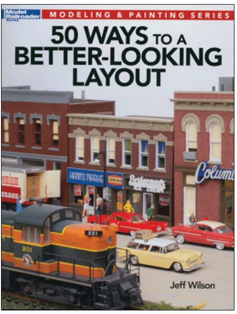 Book cover of '50 Ways to a Better-Looking Layout' by Jeff Wilson with model train set and buildings.
