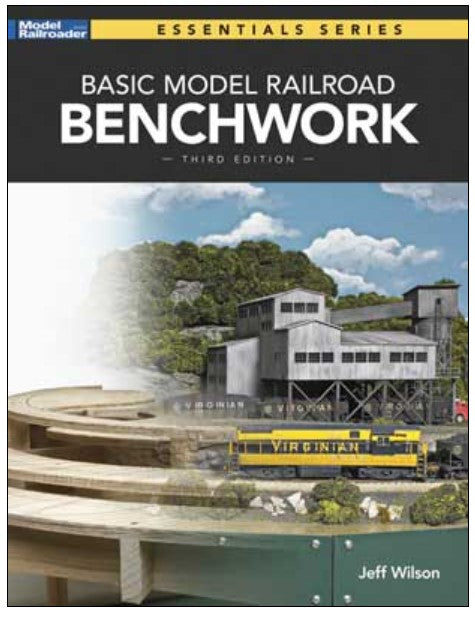 Book cover of 'Basic Model Railroad Benchmarkwork' with a train and building on a model railroad layout.