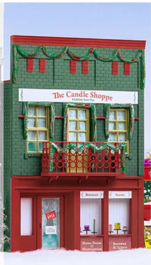 Model of a building facade with 'The Candle Shoppe' sign on a snowy background