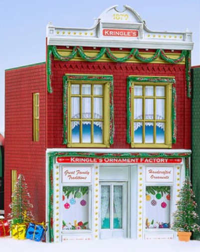 Model of Kringle's Ornament Factory with festive decorations against a clear blue sky.